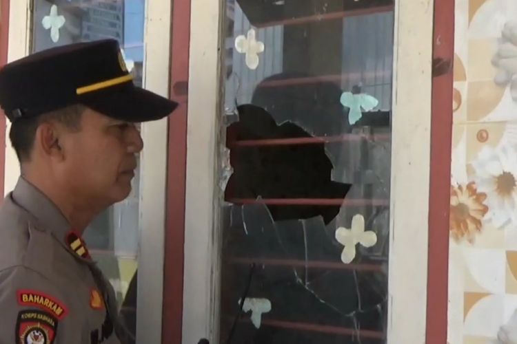 Polisi menunjukkan kaca pecah di salah satu fasilitas umum akibat lembaran batu dari dua kelompak perguruan pencak silat yang bentrok, di Kabupaten Tulungagung Jawa Timur, Sabtu (13/01/2024).