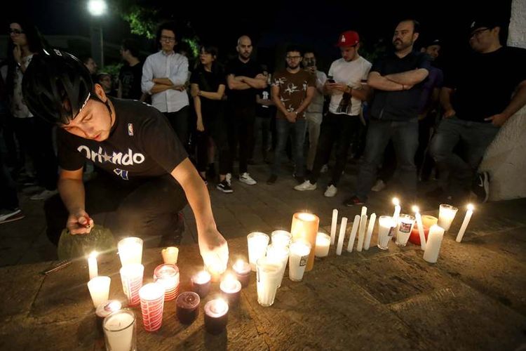 Kerabat dan rekan mahasiswa yang diculik dan dibunuh di Meksiko menyalakan lilin dalam aksi protes di Guadalajara, Senin (23/4/2018) malam.