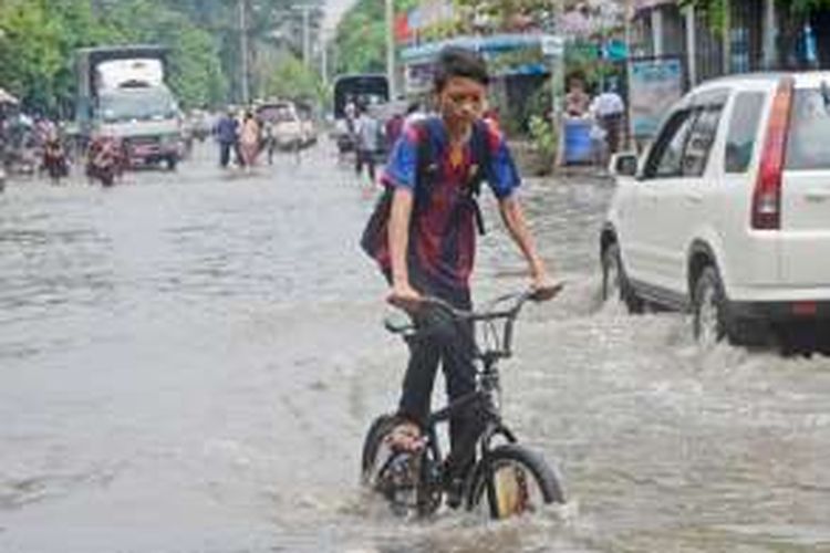 Banjir menggenangi jalan-jalan di kota Mandalay, Myanmar utara, Senin (15/8/2016).