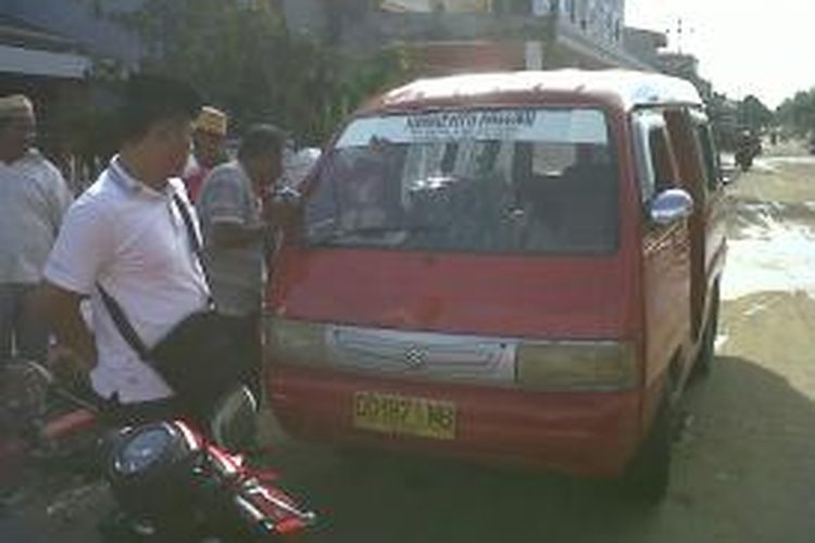 Sejumlah pengguna jalan di Kabupaten Bone, Sulawesi Selatan tengah berkerumun di mobil angkot yang terbakar sesaat setelah dipadamkan oleh petugas pemadam kebakaran. Selasa, (06/08/2013).