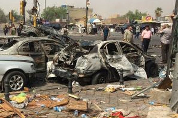 Beberapa mobil yang hangus akibat serangan bom di sebuah perempatan yang sibuk di Baghdad, Selasa (26/8/2014) pagi masih teronggok di tempatnya semula. Akibat ledakan itu sedikitnya 15 orang tewas dan 37 orang terluka.