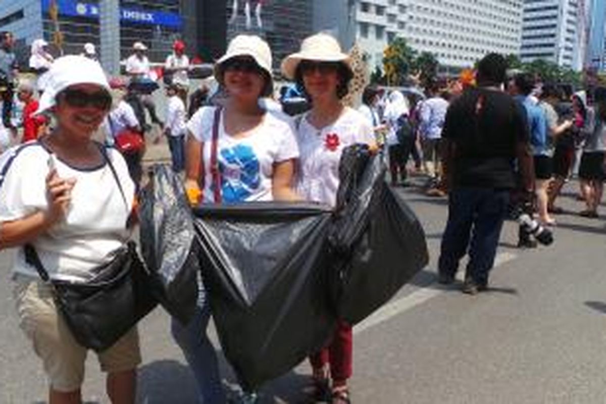 Tiga wanita ini melakukan aksi bersih sampah di Jalan MH Thamrin, saat perayaan pelantikan Joko Widodo dan Jusuf Kalla sebagai presiden dan wakil presiden. Senin (20/10/2014).