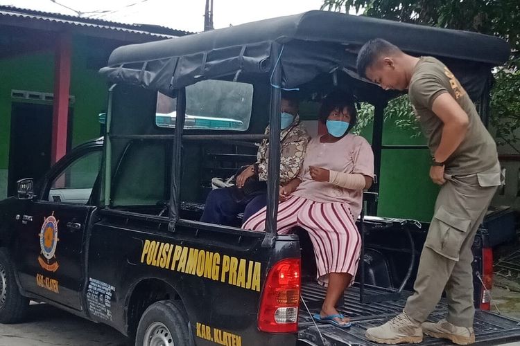 Petugas Satpol PP Klaten mengamankan ibu yang mengajak anaknya mengemis di lampu merah simpang empat Mlaran, Desa Nglinggi, Klaten Selatan, Klaten, Jawa Tengah.