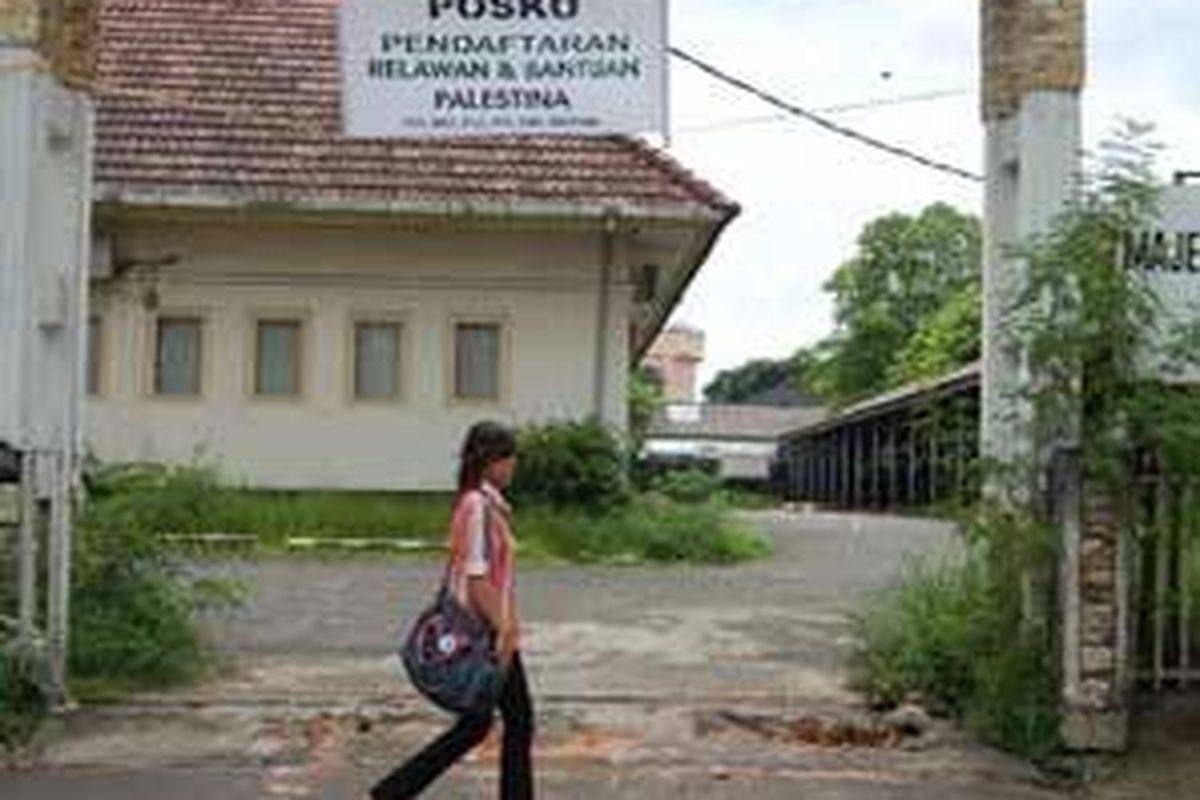 Seorang warga berjalan di depan Posko Gabungan Relawan dan Bantuan Untuk Palestina di kantor Majelis Ulama Indonesia Sumatera Selatan, Sabtu (3/1). Sebagai bentuk kepedulian terhadap korban perang di Jalur Gaza, saat ini mulai bermunculan puluhan posko relawan dan bantuan Palestina.