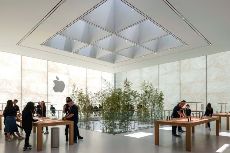 Lantai atas interior gedung Apple Cotai Store Macau. Meja display ditata sedemikian rupa dan menonjolkan tanaman bambu yang menjulang dari lantai di bawahnya.