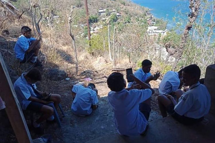 Siswa-siswi di SMPN Satu Atap 3 Ile Ape Timur Hamahena, Kabupaten Lembata, NTT, harus naik ke lereng gunung Ile Lewotolok untuk mengikuti ujian online, pada Selasa (19/10/2021).