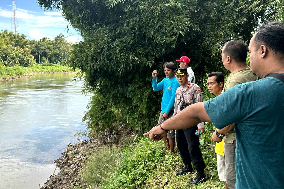 Seeorang saksi mata menunjuk titik lokasi dimana Safrian Adinata tenggelam di aliran Sungai Brantas di Dusun Maron, Desa Selokajang, Kecamatan Srengat, Kabupaten Blitar, Senin (7/4/2025)