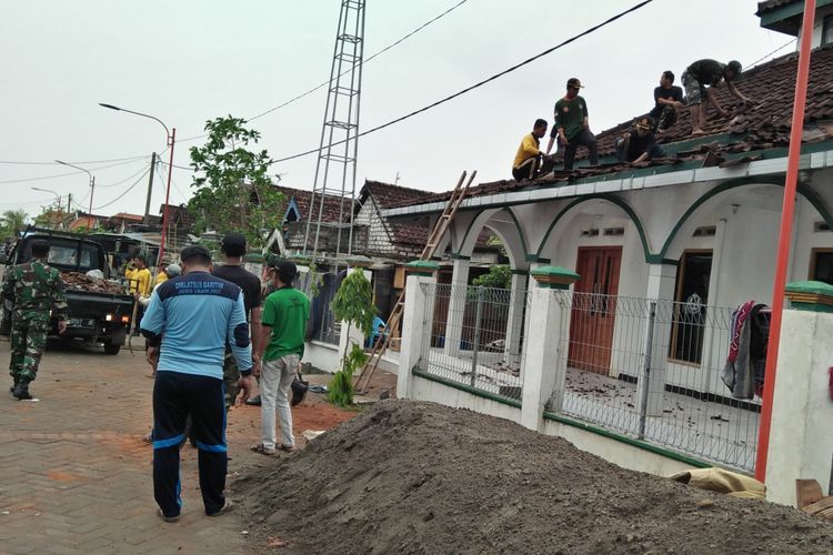 Polisi, anggota TNI, Satpol PP, dan aparat pemerintah setempat bergotong royong memperbaiki rumah ibadah yang rusak di Desa Banter, Kecamatan Benjeng, Gresik.