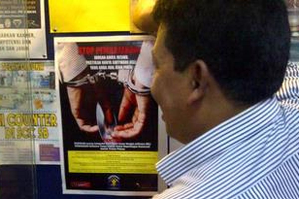 Kepala Sub Direktorat Penindakan dan Pemantauan Direktorat Jenderal Hak Kekayaan Intelektual Kementerian Hukum dan HAM RI, Johno Suprianto menempelkan poster sosialisasi stop pembajakan software di pusat penjualan komputer di Matahari Mal Semarang, Senin (16/7/2012)