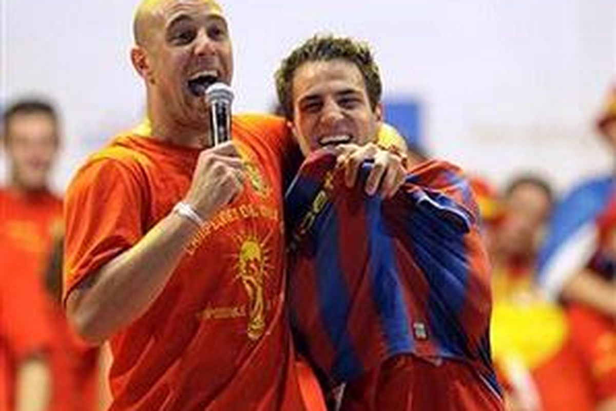 Kiper Spanyol Pepe Reina (kiri) bergembira bersama gelandang Cesc Fabregas dalam perayaan kemenangan Piala Dunia 2010 ketika mereka tiba di Madrid pada Senin (12/7/2010).