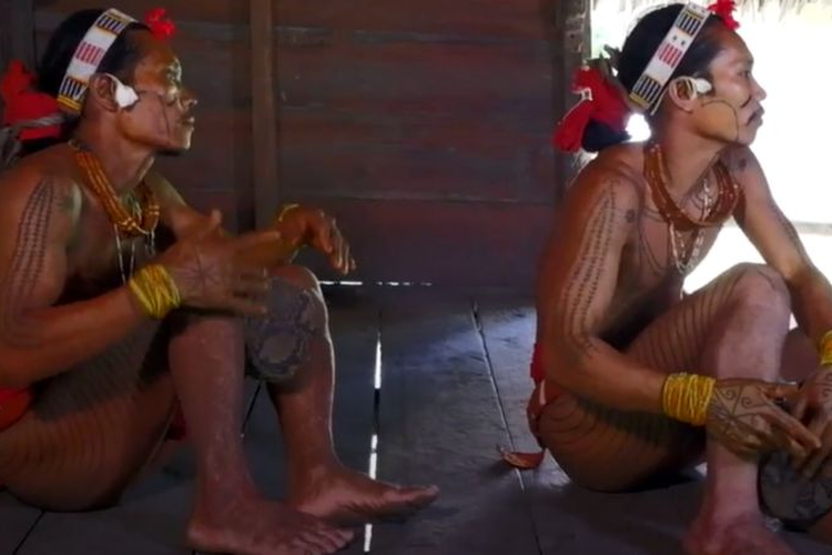 Sikerei membunyikan gendang gajeumak, mengiringi lagu khas Mentawai.