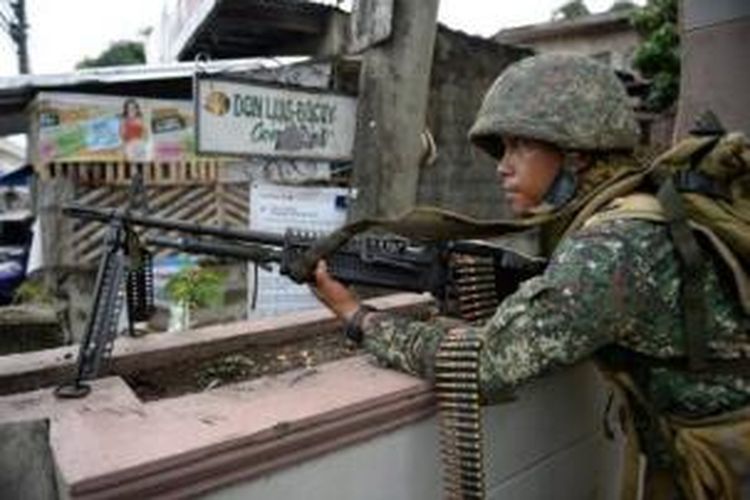 Seorang prajurit marinir Filipina bersenjata berat bersiaga di salah satu sudut kota Zamboanga, Filipina selatan. Selama empat hari terakhir militer Filipina dan pasukan pemberontak MNLF berhadap-hadapan di kota Zamboanga.