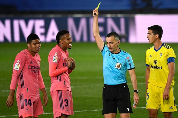 Pemain Real Madrid, Eder Militao (3), saat diganjar kartu kuning oleh wasit Santiago Jaime Latre dalam laga kontra Cadiz CF, 17 Oktober 2020.