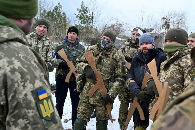 Tentara cadangan Ukraina memegang replika kayu senapan Kalashnikov, dalam latihan militer di dekat Kiev pada Sabtu (25/12/2021). Para peserta pelatihan adalah bagian dari batalyon cadangan yang dibentuk untuk melindungi sebuah distrik di Kiev jika terjadi serangan terhadap kota terbesar di Ukraina itu. Puluhan warga sipil bergabung dengan tentara cadangan Ukraina dalam beberapa bulan terakhir, karena kekhawatiran meningkat bahwa Rusia, yang menurut Kiev telah mengumpulkan sekitar 100.000 tentara di sisi perbatasannya, sedang merencanakan serangan skala besar.