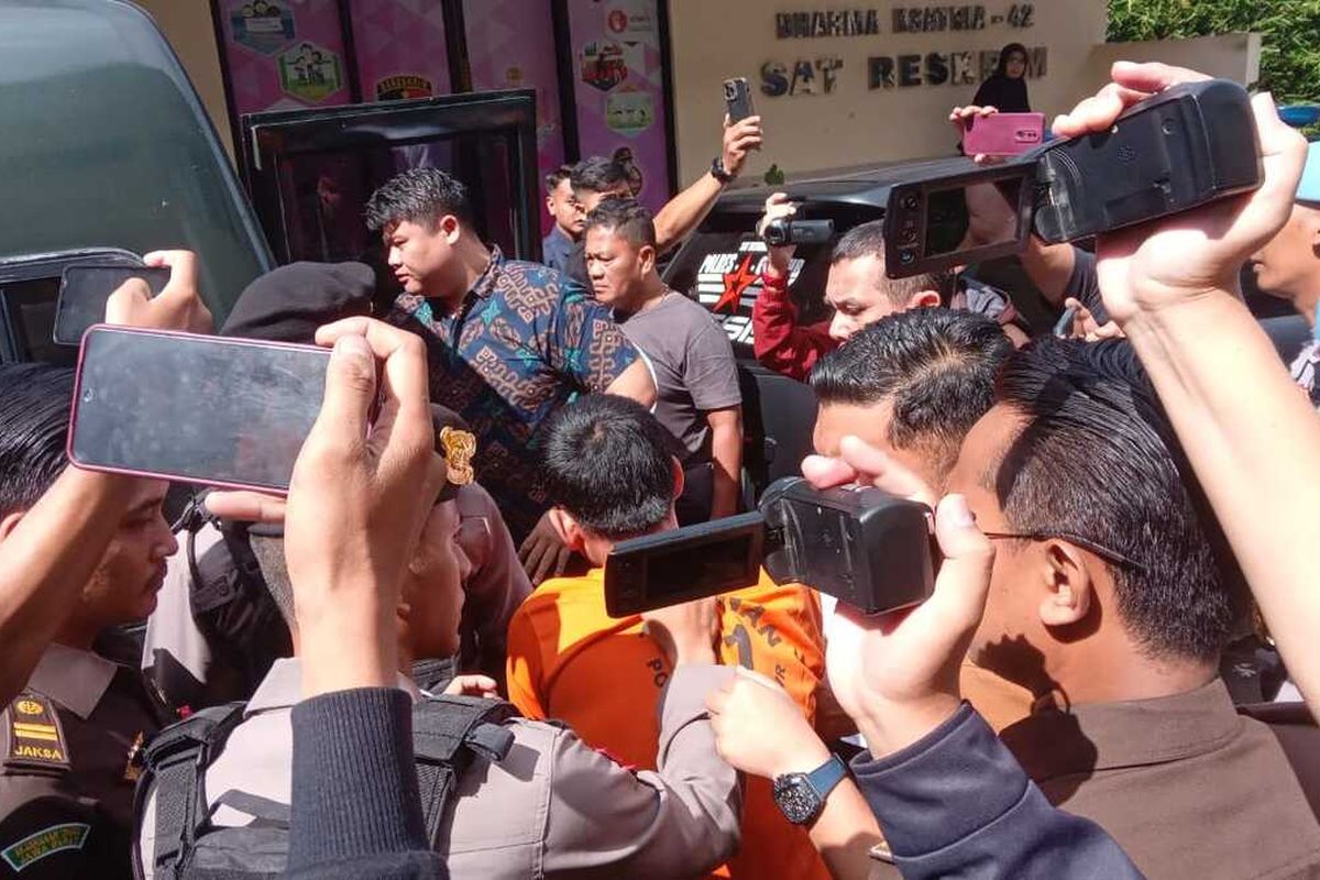 Petugas menggelandang seorang tahanan kabur yang berhasil ditangkap ke dalam mobil tahanan kejaksaan di mako Polres Cianjur, Senin (8/4/2024).