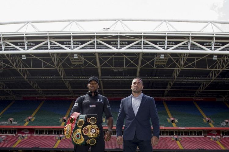 Britains Anthony Joshua (L) and Bulgarias Kubrat Pulev (R) stand on the pitch at the Principality Stadium in Cardiff on September 11, 2017 during a promotional event for their heavyweight world title boxing match. 