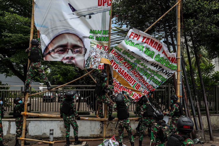 Prajurit TNI menertibkan spanduk tidak berizin saat patroli keamanan di Tanah Abang, Jakarta Pusat, Jumat (20/11/2020). Pangdam Jaya Mayjen TNI Dudung Abdurachman, memerintahkan jajarannya untuk mencopot spanduk dan baliho pemimpin Front Pembela Islam (FPI) Rizieq Shihab.