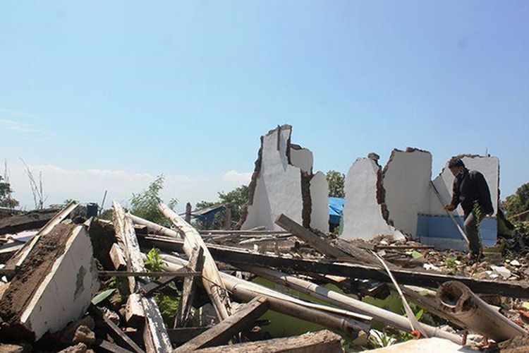 Seorang warga melintas di antara reruntuhan puing-puing bangunan di Kampung Rawacina, Nagrak, Kabupaten Cianjur, Jawa Barat, Minggu (10/11/2023).