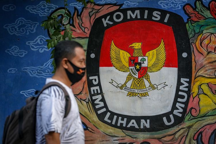 Warga melintas di depan mural bertema pemilihan umum di kawasan Pasar Anyar, Kota Tangerang, Banten, Kamis (7/5/2020). Presiden Joko Widodo menunda pemungutan suara Pemilihan Kepala Daerah (Pilkada) 2020 hingga Desember 2020 akibat wabah COVID-19. ANTARA FOTO/Fauzan/aww.