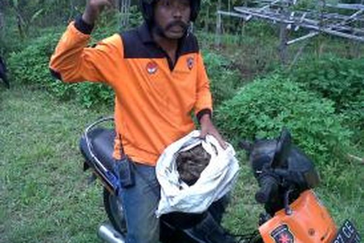 Seorang anggota tim SAR Malang, saat membawa potongan kepala korban mutilasi di Kabupaten Malang, setelah berhasil ditemukan anggota tim SAR dan warga yang melakukan pencarian. Senin (11/11/2013).