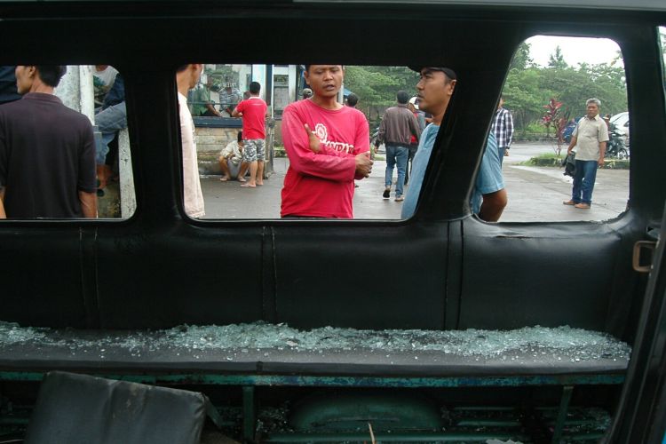 Kondisi salah satu angkutan perkotaan (angkot) rusak parah paska-bentrok di Terminal Laladon, Kamis (23/3/2017).