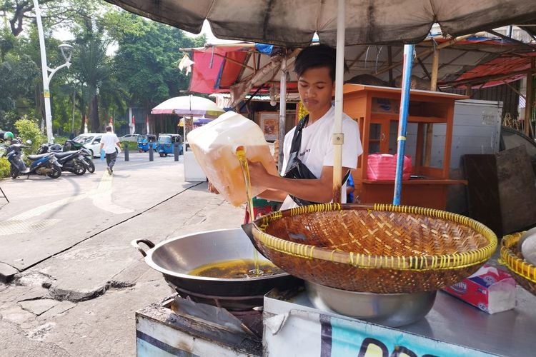 Pedagang gorengan, Adi (21), sedang mempersiapkan jualannya di kawasan Cikini, Menteng, Jakarta Pusat, Selasa (15/8/2023).