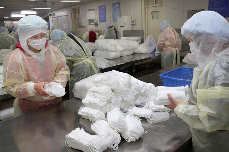 Pekerja di pabrik masker dan jumpsuit medis di Nantong, Provinsi Jiangsu, China. Gambar diambil pada 27 Januari 2020. China mulai kehabisan stok perkakas pencegahan medis, begitu diumumkan keharusan setiap orang mengenakan masker dan pengaman lain terkait wabah varian baru virus corona (2019-nCoV). 