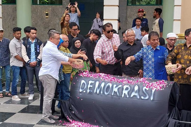 Sivitas akademika UII tabur bunga diatas keranda bertuliskan  Demokrasi usai membacakan pernyataan sikap di di depan Auditorium Prof. K.H. Abdul Kahar Muzakkir, Kampus Terpadu UII Jalan Kaliurang Km 14, Kabupaten Sleman, Kamis (14/03/2024).