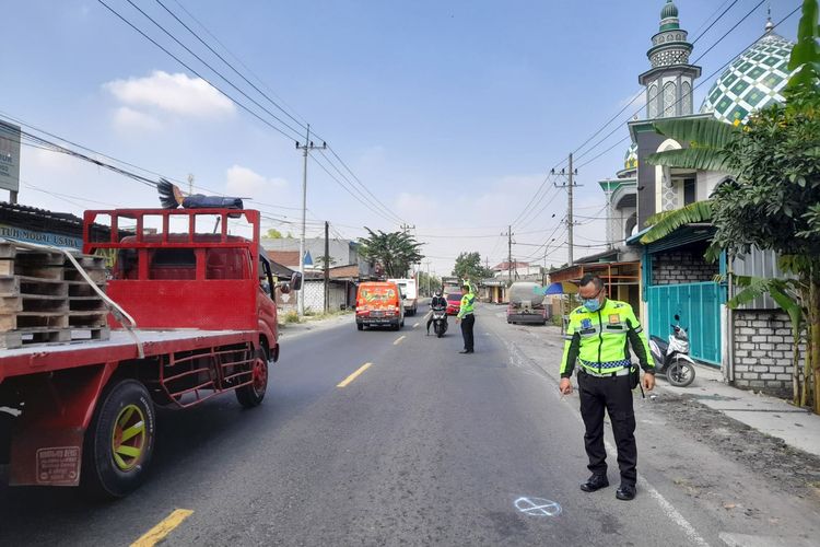 Petugas kepolisian saat melakukan olah di lokasi kecelakaan yang menewaskan ibu dan anak di Jalan Raya Desa Putat Lor, Kecamatan Menganti, Gresik, Jawa Timur.