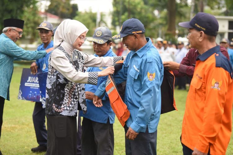 Wali Kota Kediri Vinanda Prameswati menyematkan atribut parkir QRIS kepada juru parkir.