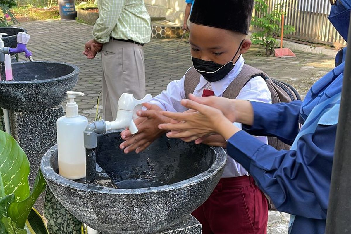 Guru SLB Negeri Kota Depok mengajarkan dan memastikan siswa mencuci tangan dan mengikuti protokol kesehatan selama PTMT, Selasa (12/10/2021) 