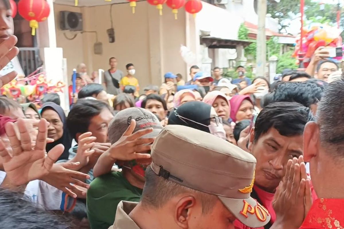 Warga yang berebut angpao ketika perayaan Hari Raya Imlek 2574/2023 di Keleteng Hok Lay Kiong, Kota Bekasi, Minggu (22/1/2023). Ratusan warga itu diketahui sudah menunggu di depan kelenteng sejak pagi sekitar pukul 07.00 WIB.