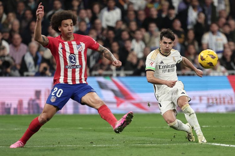 Brahim Diaz (kanan) menendang bola melewati Axet Witsel (kiri) dalam pertandingan Real Madrid vs Atletico Madrid pada pekan ke-23 Liga Spanyol 2023-2024 di Stadion Santiago Bernabeu, Senin (5/2/2024) dini hari WIB. (Foto oleh Thomas COEX / AFP)