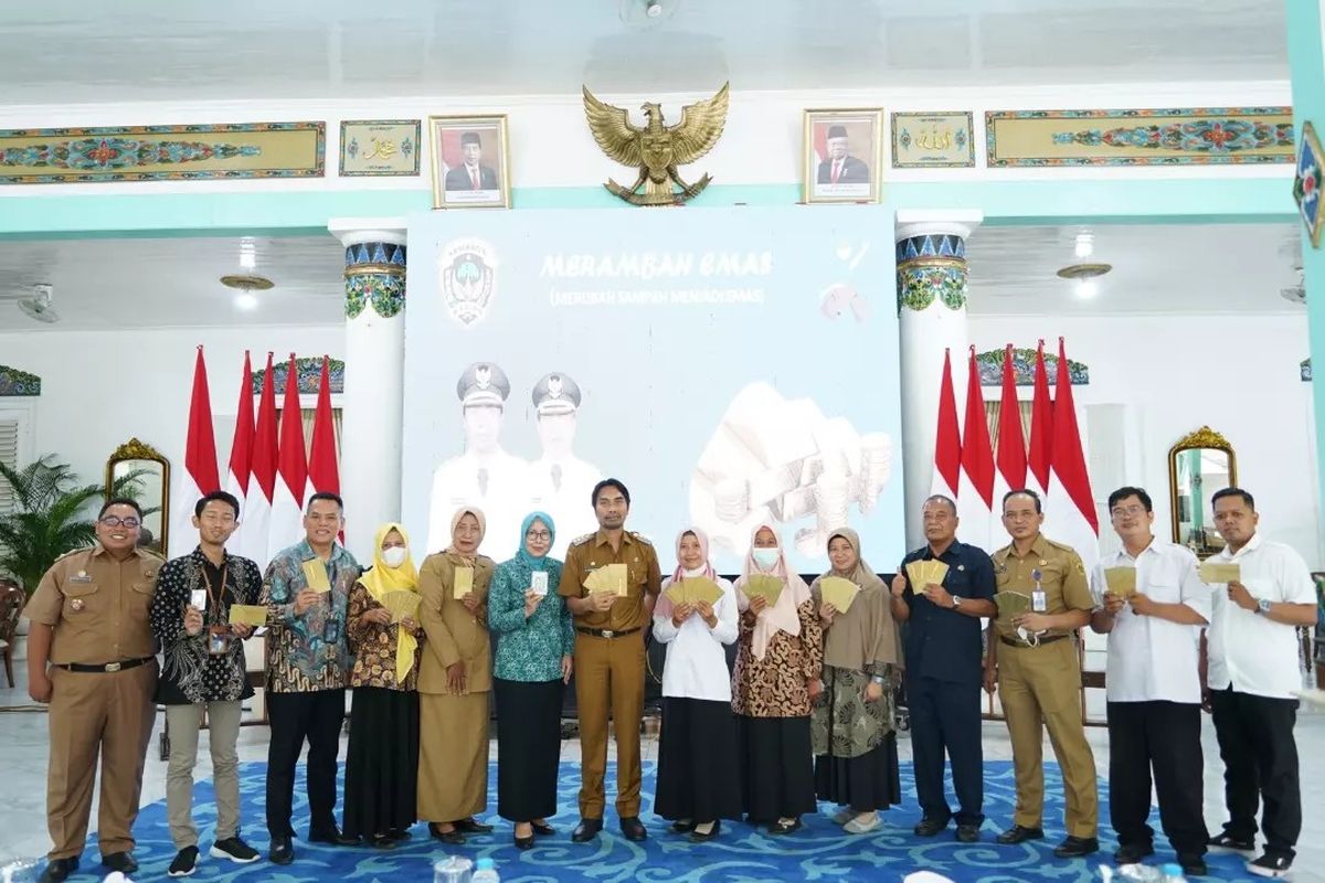 TABUNGAN EMAS—Bupati Madiun, Ahmad Dawami bersama sejumlah warga menunjukkan tabungan emas yang diperoleh warga dari hasil mengumpulkan sampah dilingkungan masing-masing. 