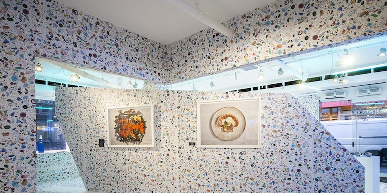 Desainer dari Shed menghias dinding dengan wallpaper yang menggambarkan puing atau kotoran plastik yang mengambang di lautan. 