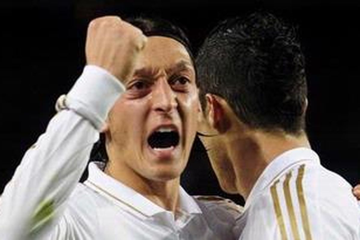 Gelandang Real Madrid, Cristiano Ronaldo (kanan), merayakan golnya ke gawang Barcelona, bersama pemberi assist, Mesut Oezil, pada pertandingan Liga BBVA, di Camp Nou, Sabtu (21/4/2012).