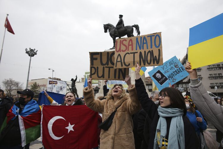 Wanita memegang bendera Turki dan Ukraina meneriakkan slogan-slogan ketika orang-orang termasuk orang Ukraina memprotes invasi Rusia ke Ukraina, Turki, Sabtu, 26 Februari 2022. 