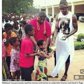 Emmanuel Adebayor sedang membagikan uang kepada anak-anak berkekurangan di Togo.