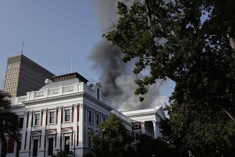 Asap mengepul dari atap gedung Parlemen Afrika Selatan di Cape Town, Minggu (2/1/2022).