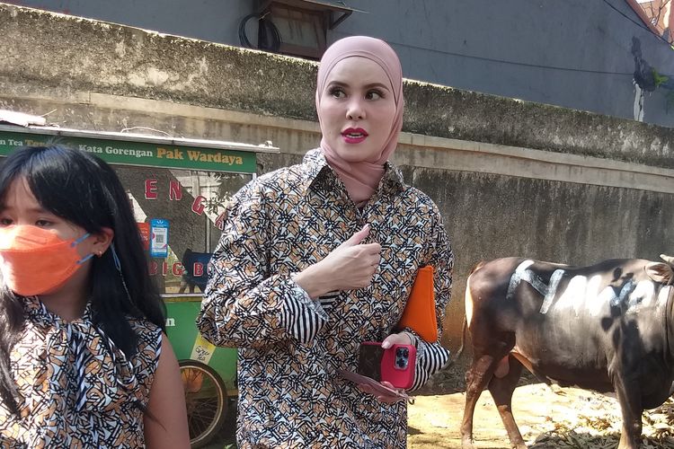 Artis Angel Lelga bersama anaknya, Hawra berfoto di depan sapinya yang akan dikurbankan di Idul Adha tahun ini, di kawasan Jagakarsa, Jakarta Selatan, Minggu (10/7/2022).