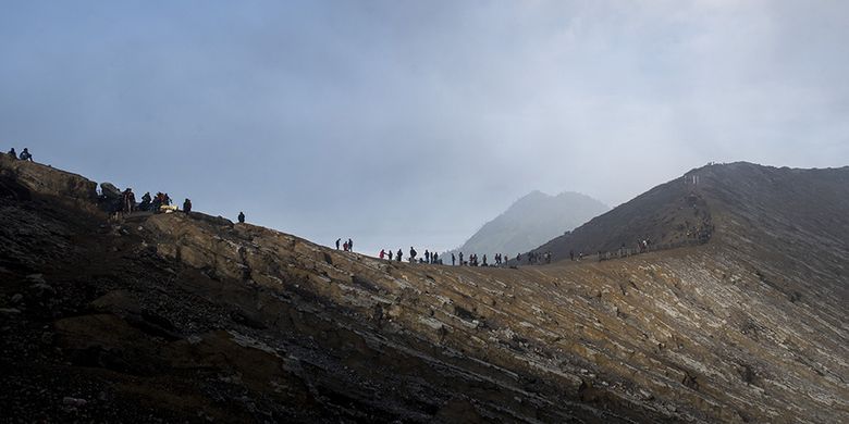 Ratusan wisatawan menikmati pemandangan dari puncak Gunung Ijen, Banyuwangi, Jawa Timur, Sabtu (23/6/2018). Kawah Ijen dengan kedalaman 200 meter menjadi salah satu dari dua lokasi di dunia yang memiliki fenomena api biru selain Islandia, membuat Ijen menjadi tujuan utama pendaki dari berbagai pelosok negeri hingga mancanegara.