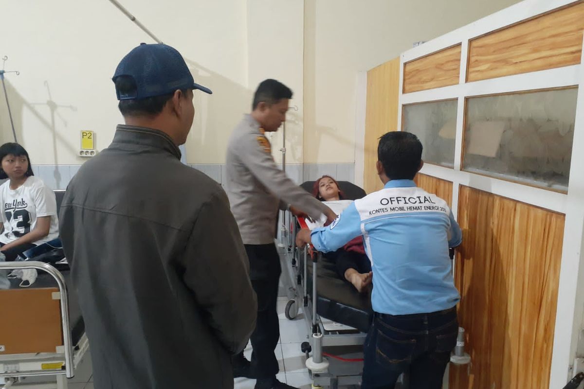 Petugas kepolisian saat mengevakuasi mahasiswa Universitas Brawijaya yang diduga keracunan saat mengikuti Kemah Kerja Mahasiswa (KKM) di Desa Jedong, Kecamatan Wagir, Kabupaten Malang, Selasa (7/2/2023).