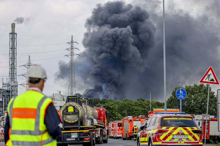 Kendaraan darurat pemadam kebakaran, layanan penyelamatan dan polisi berdiri tidak jauh dari akses jalan ke Chempark di mana awan gelap asap membubung di Leverkusen, Jerman, Selasa, 27 Juli 2021. 