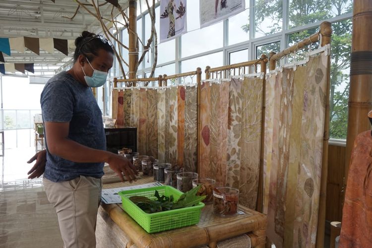 Seorang pengunjung Sumowono Bamboo Garden melihat kain eco dyeing.