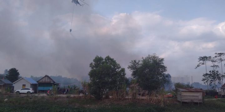 Satu helikopter Waterbombing terlihat berupaya memadamkan kebakaran lahan yang berada disamping kawasan wisma atlet Jakabaring, Palembang, Sumatera Selatan, Selasa (21/8/2018).