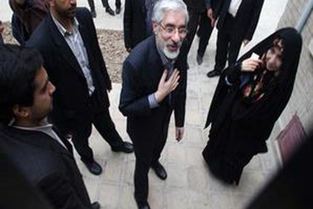 Mir Hossein Mousavi berdiri bersama istrinya Zahra Rahnavard di luar kantornya. 