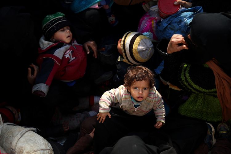 Anak-anak bersama warga sipil lainnya melarikan diri dari sebuah kelompok radikal di Suriah, duduk di belakang sebuah truk dekat Baghuz, Suriah timur, Senin (11/2/2019) waktu setempat. Jutaan anak menjadi korban dalam perang saudara di Suriah yang berlangsung sejak 2011, selain dibunuh, disiksa, dan diculik, mereka juga menderita gizi buruk dan kerap menjadi tameng hidup di medan perang.