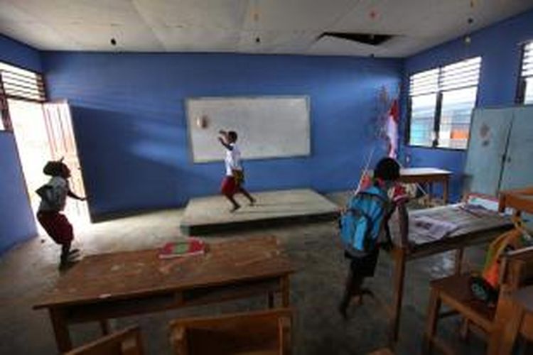 Alex dan Fredy, siswa kelas 4 SD Inpres Tiom, Lanny Jaya, Papua, bermain bola di dalam kelas, Selasa (28/7/2015). Kegiatan belajar di sekolah tersebut baru dimulai untuk kelas 1 dan 2, sementara kelas lain belum berkegiatan karena guru belum hadir. Beberapa orang tua murid pun baru mendaftarkan anaknya ke sekolah.