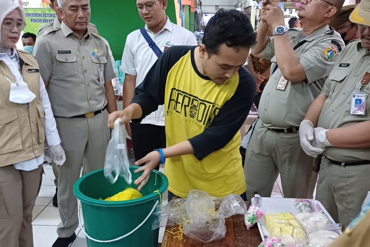 Seorang pedagang saat diminta memusnahkan sendiri makanan yang mengandung zat berbahaya saat Pemkot Jakarta Selatan melakukan sidak di Pasar Santa, Kebayoran Baru, Jakarta Selatan, Senin (1/4/2024).