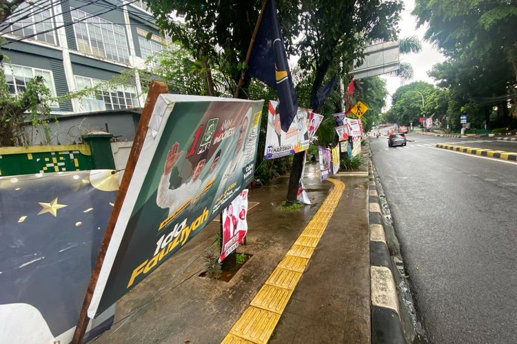 Alat peraga kampanye (APK) terpasang di trotoar seberang Kantor Kecamatan Pasar Minggu, Jakarta Selatan, Senin (30/1/2024).